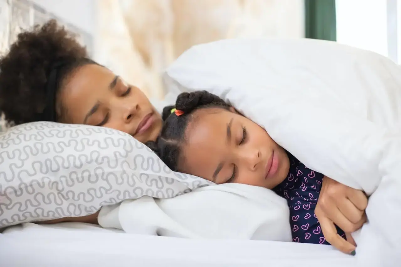 Woman and girl sleeping in a bed